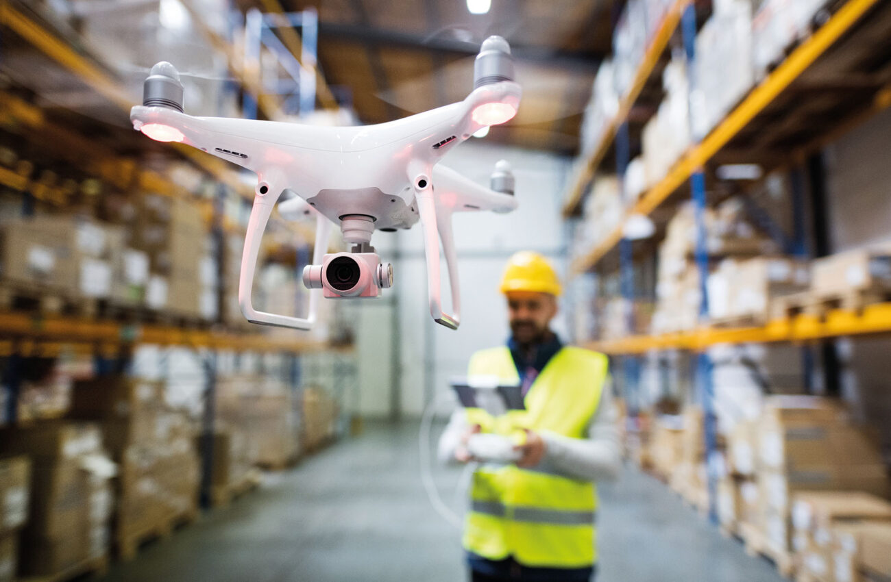 Man with drone in a warehouse.